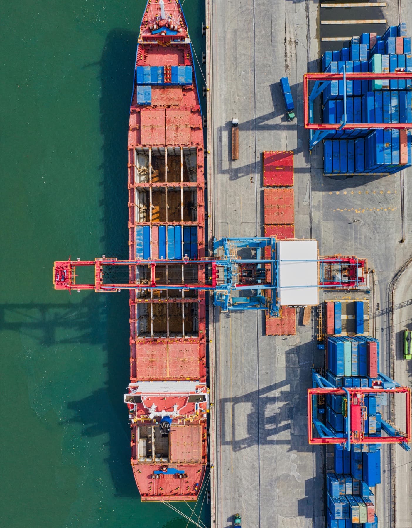 Aerial view of a container ship being loaded by a gantry crane at port